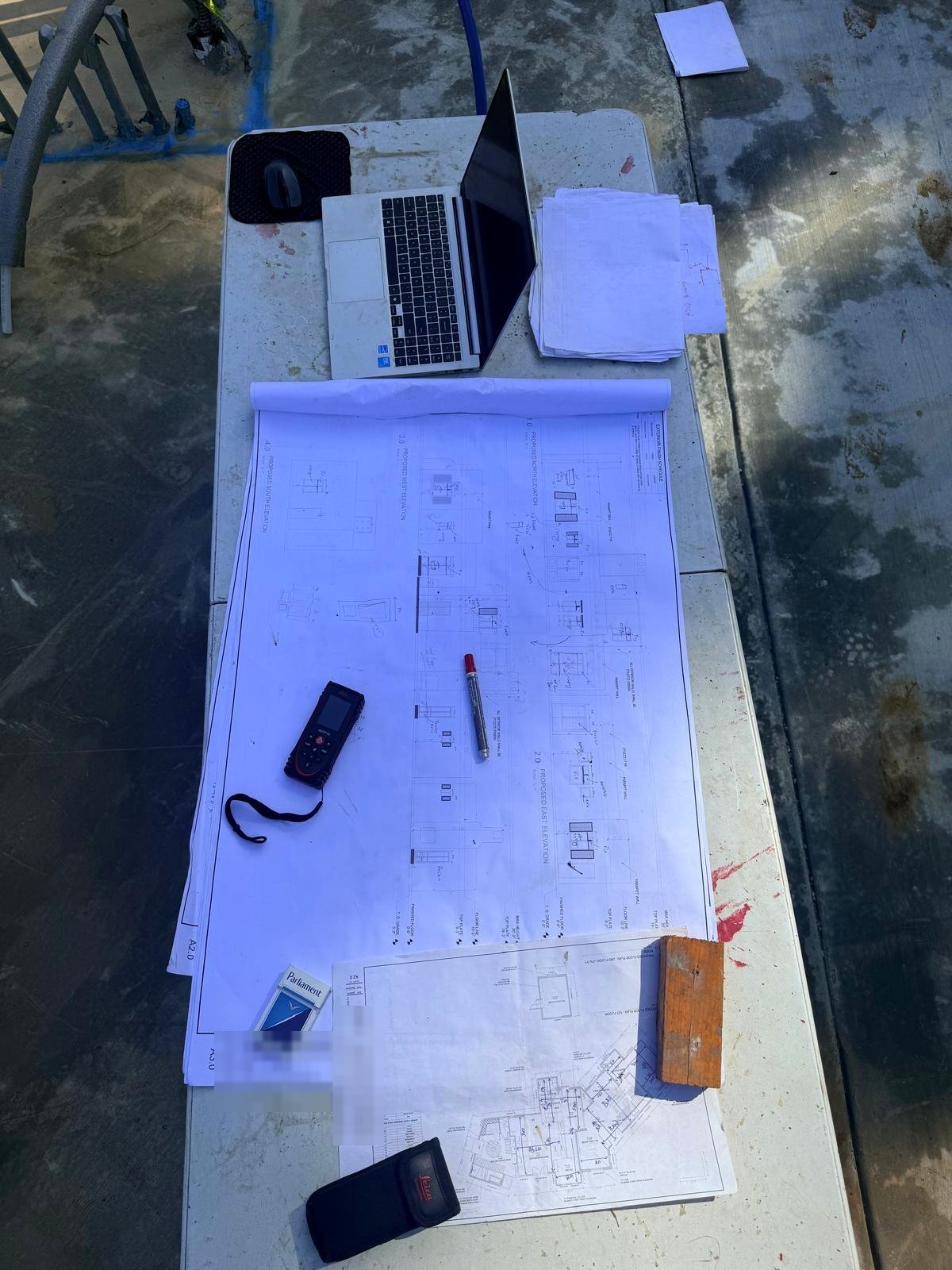 Construction drawings and a laser measure on the site table during the Palisades rebuild